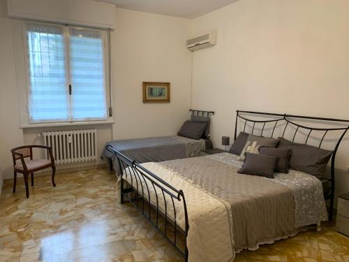 フィレンツェにあるCasa Bianca Firenzeのベッドルーム1室(ベッド2台、椅子、窓付)
