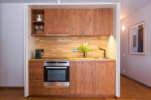 a kitchen with wooden cabinets and a sink and a stove at GuestReady - Rivoli Studio in Porto