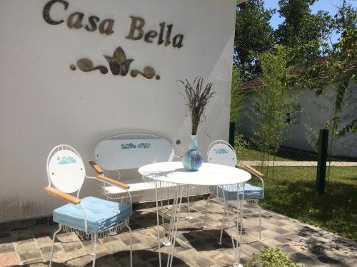 two tables and chairs in front of a sign at Dve kuce pored jezera in Palić