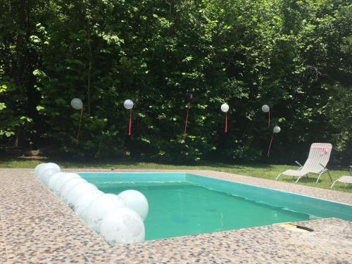 a swimming pool with a chair and a table and a chair at Dve kuce pored jezera in Palić