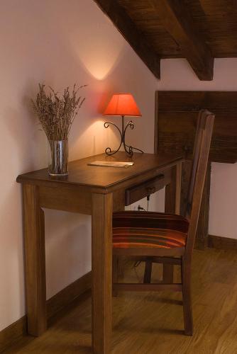 a wooden desk with a lamp and a chair at Posada Ruilobuca in Ruiloba