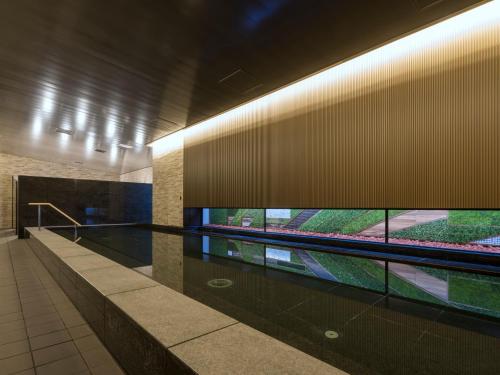 a building with a swimming pool in the middle at Keio Prelia Hotel Sapporo in Sapporo