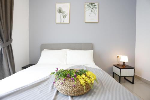 a bedroom with a bed with a basket of flowers on it at Pinnacle Tower Homestay by Home Cube in Johor Bahru