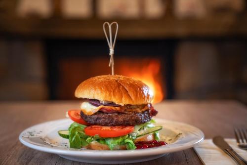 a hamburger on a plate on a table at Hotel Eco Tatry Holiday& Spa in Kościelisko
