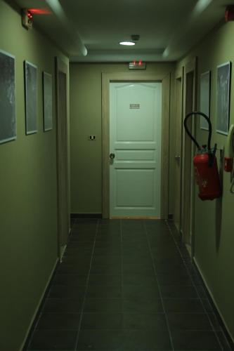 a hallway with a white door and a red bag at MONDIAL HOTEL in Tunis