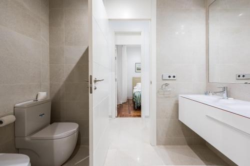biała łazienka z toaletą i umywalką w obiekcie PUERTA DEL SOL CITY CENTER III w Madrycie