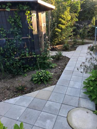 a garden with a stone walkway next to a house at Molino in Bønnerup Strand
