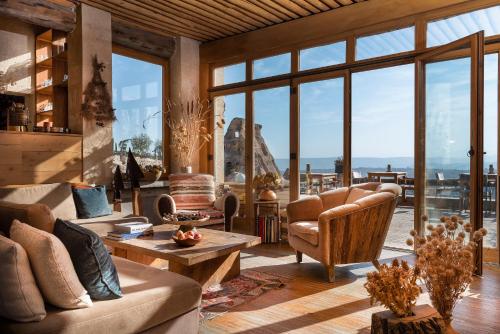 a living room with couches and tables and windows at Argos in Cappadocia in Uchisar