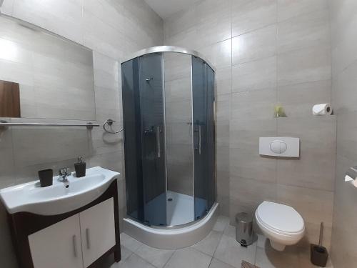 ein Badezimmer mit Dusche, Toilette und Waschbecken in der Unterkunft Apartments MODOM in Liptovský Mikuláš