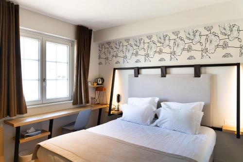 - une chambre avec un grand lit et des draps blancs dans l'établissement Aigle d'Or - Strasbourg Nord, à Reichstett