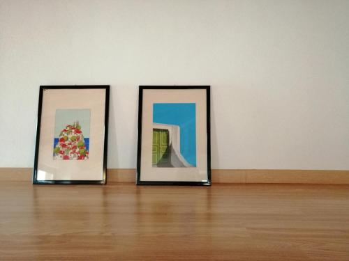 two framed pictures sitting on a floor in a room at IseoLakeRental - Casa del Pescatore in Riva di Solto