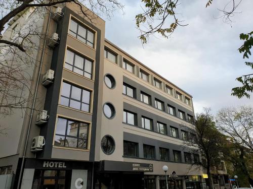 a building with a clock on the side of it at Хотел ЦЕНТРАЛ in Stara Zagora