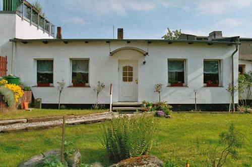 une maison blanche avec une terrasse couverte et une cour dans l'établissement Ruegen_Fewo 35, à Putbus