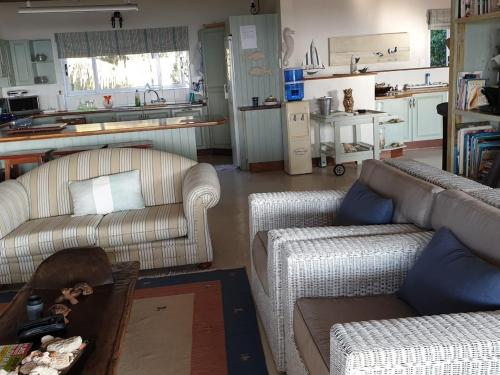 a living room with two couches and a kitchen at Kangela 11 in Ponta Malongane
