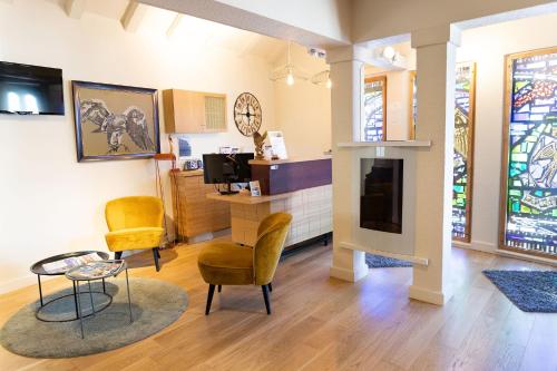 a living room with two chairs and a table and a tv at Aigle d'Or - Strasbourg Nord in Reichstett