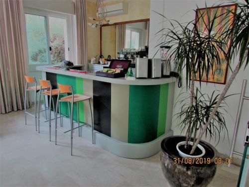 una cucina con bancone colorato e sgabelli di Hotel Villa Fiorita a Milano Marittima
