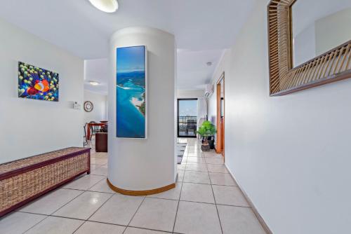 a hallway with white walls and a large painting on the wall at Ambience of Airlie - Airlie Beach in Airlie Beach