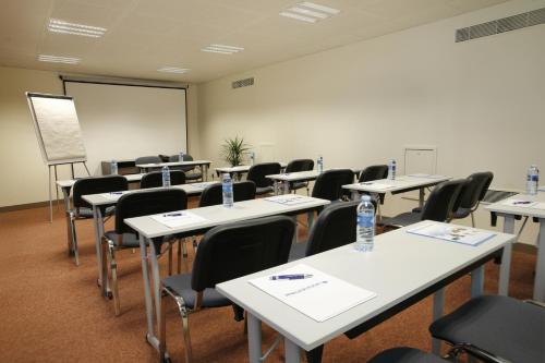 an empty classroom with tables and chairs and a whiteboard at Residhotel Lyon Lamartine in Tassin-la-Demi-Lune