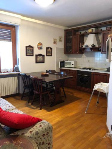 a living room with a table and a kitchen at Elegante appartamento in centro a bardonecchia in Bardonecchia