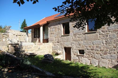 a stone house with a stone wall at Casa Fonte Do Laboreiro in Castro Laboreiro