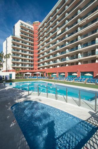 a large hotel with a swimming pool in front of a building at Pierre & Vacances Benalmádena Príncipe in Benalmádena