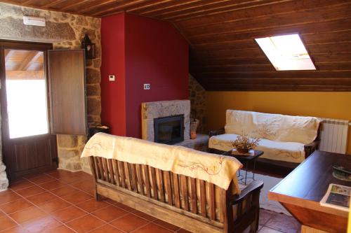 a living room with a couch and a fireplace at Casa Fonte Do Laboreiro in Castro Laboreiro