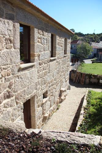 a stone building with a door on the side of it at Casa Fonte Do Laboreiro in Castro Laboreiro