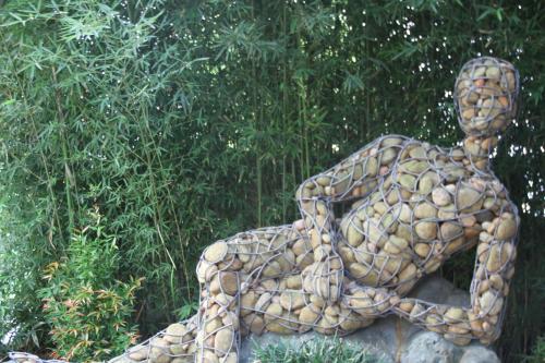 a statue of a man sitting on a rock at Chandys Windy Woods Munnar in Munnar