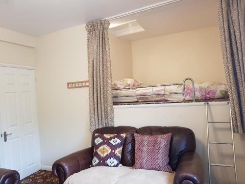 - un salon avec un canapé et des lits superposés dans l'établissement Saltburn Holidays 4 Park View, à Loftus