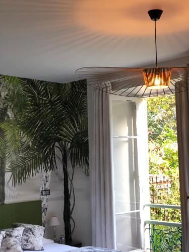 a bedroom with a palm tree on the wall and a window at Hotel Villa Victoria in Nice