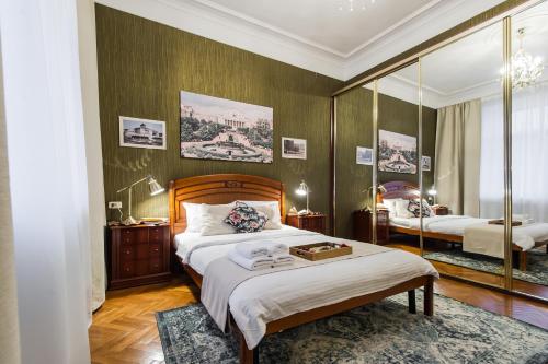 モスクワにあるGMApartments White Houseのベッド2台と鏡が備わるホテルルームです。
