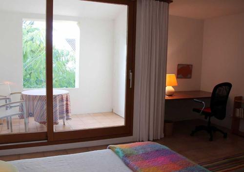 1 dormitorio con escritorio y ventana en Paradix holiday apartment - gîte 2, 2 pers, en Nissan-lez-Enserune