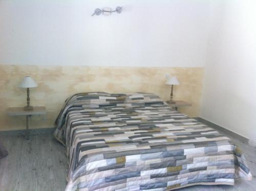 a bed in a room with two tables and two lamps at Domaine Casa Andria in Barbaggio