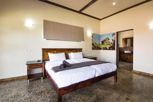 a bedroom with a large bed and a night stand at Stephan's Guest House in Port Shepstone