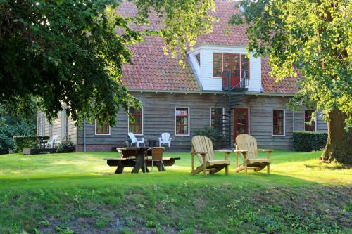 a group of chairs and a table in front of a house at Graanzicht in Midwolda