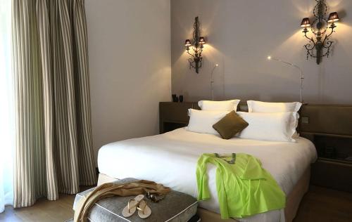 a bedroom with a bed with a green bag on it at Domaine De Manville in Les Baux-de-Provence