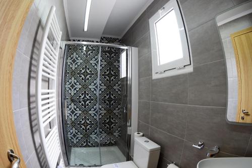 a bathroom with a shower and a toilet and a window at Alexandros in Giannitsa