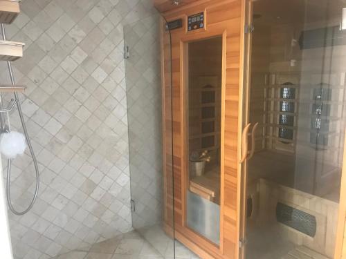a shower with a glass door in a bathroom at Chambres chez l'habitant Villa l'Île aux Anges in Saint-Andre-de-la-Roche