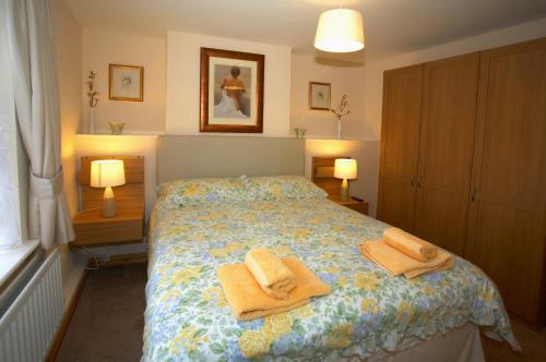 a bedroom with a bed with towels on it at Saltburn Holidays Primrose Cottage in Guisborough