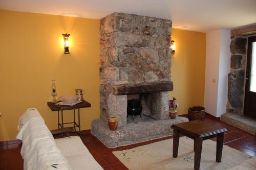 a living room with a large stone fireplace at Casa Fonte Do Laboreiro in Castro Laboreiro