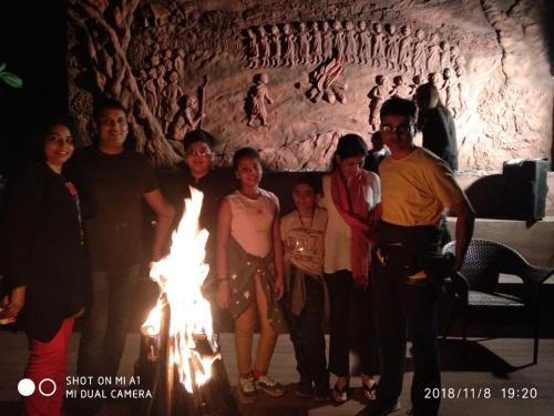 a group of people standing in front of a fire at Chandys Windy Woods Munnar in Munnar