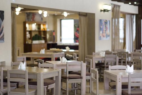 Nechkino Hotel في Sarapul: غرفة طعام مع طاولات وكراسي بيضاء