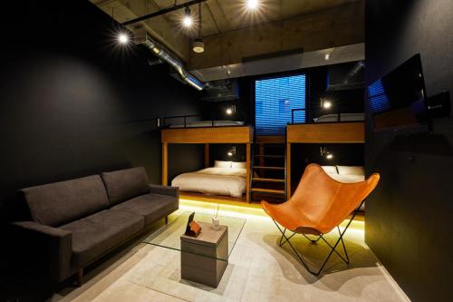 a living room with a couch and a bed at ZONK HOTEL Nakasu-Deaibashi in Fukuoka
