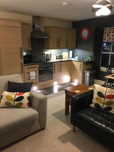 a living room with a couch and a table at Historic Peel House Serviced Apartments in Burton upon Trent