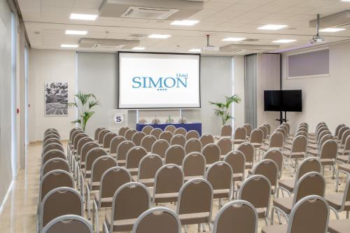 a conference room with chairs and a screen at Simon Hotel in Pomezia
