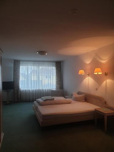 Hotel zur Altstadt - Garni في لودنشايد: غرفة نوم بسريرين ونافذة