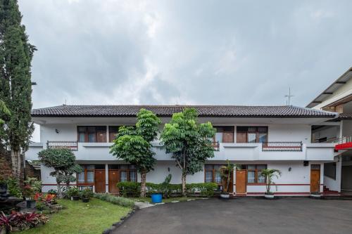 a white building with trees in front of it at Narima Resort Hotel in Lembang