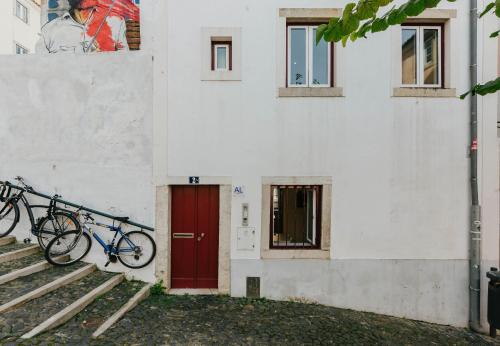 a bike parked next to a building with a red door at RENT4REST LISBON DOWNTOWN TINY STUDIO Apartments in Lisbon