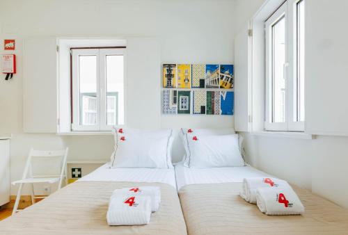 リスボンにあるRENT4REST LISBON DOWNTOWN TINY STUDIO Apartmentsの白い壁と窓が特徴のベッドルーム1室(ベッド2台付)
