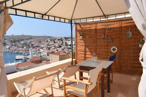 a dining room with a table and chairs and a large window at Marina Castellana Studios in Halki